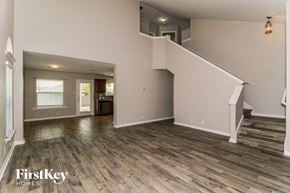 New Braunfels house for rent - A spacious living room with wood flooring and a staircase leading to the upper level.