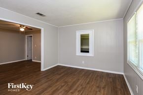 Kennesaw house for rent - A room with wooden floors and white walls, with a window on the right side.