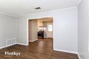 Kennesaw house for rent - A room with wooden floors and white walls, with a doorway leading to another room.