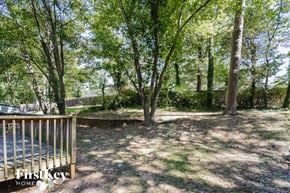 Kennesaw house for rent - A backyard with a wooden deck and trees.