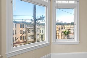 San Francisco apartment for rent - A view of a cityscape through a window with a white frame.
