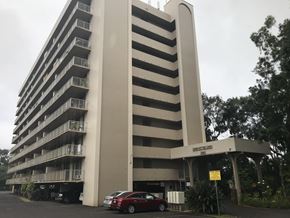 Wahiawa apartment for rent - A tall building with a parking lot in front of it.
