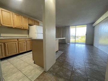 Wahiawa apartment for rent - A kitchen with wooden cabinets and a tiled floor.