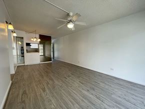 Honolulu apartment for rent - A room with a ceiling fan and wooden flooring.