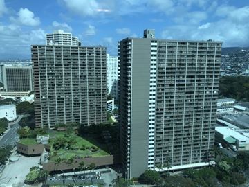 Honolulu apartment for rent - Two large buildings are surrounded by greenery.