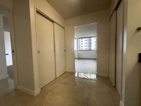 Honolulu apartment for rent - A hallway with tiled floors and white walls.
