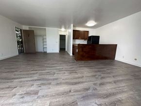 Waianae apartment for rent - A spacious room with wooden flooring and white walls.