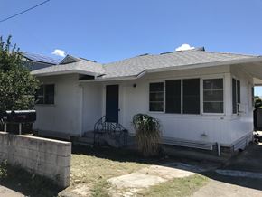Honolulu apartment for rent - A white house with a blue door and windows.