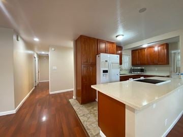 Kailua apartment for rent - A kitchen with wooden cabinets and a white refrigerator.