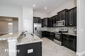 Riverview house for rent - a kitchen with black cabinets and granite counter tops and stainless steel appliances