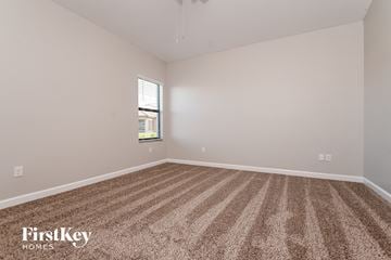 Riverview house for rent - a spacious living room with carpet and a window