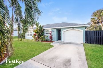 Palm Bay house for rent - a blue house with a driveway and a garage door