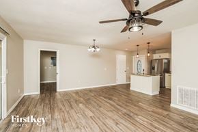 Palm Bay house for rent - an empty living room with a ceiling fan and a kitchen