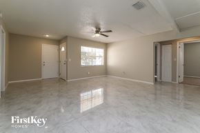 Tarpon Springs house for rent - A spacious room with a ceiling fan and a large window.