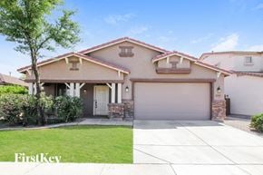 Goodyear house for rent - a house with a garage door and a lawn