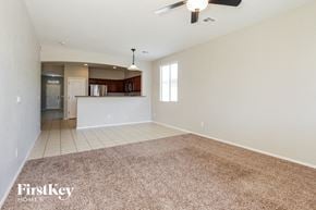 Goodyear house for rent - an empty living room with a kitchen and a ceiling fan