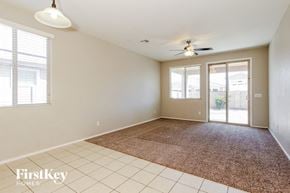 Goodyear house for rent - an empty living room with a rug and a ceiling fan