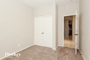 Goodyear house for rent - a bedroom with two closets and a door to a hallway