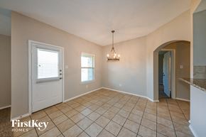 Seagoville house for rent - an empty dining room with tile flooring and a white door