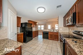 Seagoville house for rent - a kitchen with black appliances and granite counter tops