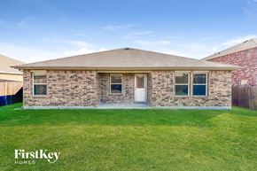 Seagoville house for rent - a small brick house with a lawn and grass
