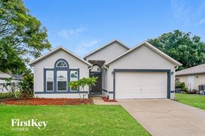 Sebastian house for rent - a white and blue house with a driveway and a garage door