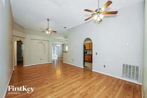 Sebastian house for rent - a living room with a hard wood floor and a ceiling fan