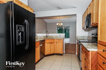 Sebastian house for rent - a kitchen with wooden cabinets and a black refrigerator