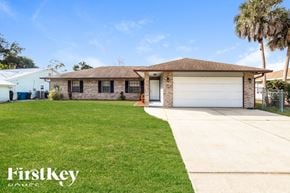 Palm Bay house for rent - A house with a brown roof and a garage door is for sale.