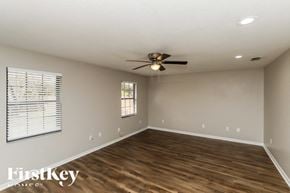 Palm Bay house for rent - A spacious room with wooden flooring and a ceiling fan.