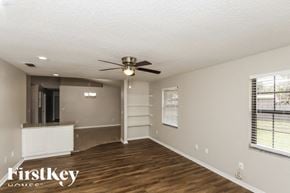 Palm Bay house for rent - A spacious room with a ceiling fan and wooden flooring.