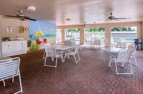 Bradenton house for rent - a large patio with tables and chairs and a swimming pool