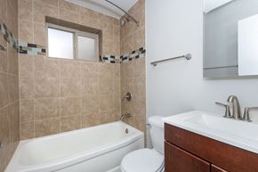 Denver apartment for rent - a bathroom with a tub sink toilet and a mirror