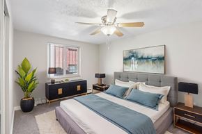Denver apartment for rent - A bedroom with a bed, nightstands, and a plant.