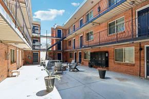Denver apartment for rent - A courtyard with a bench and a potted plant.