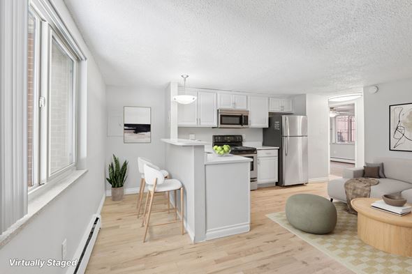 Denver apartment for rent - A modern kitchen with white cabinets and a wooden floor.