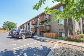 Denver apartment for rent - a parking lot with cars in front of an apartment building