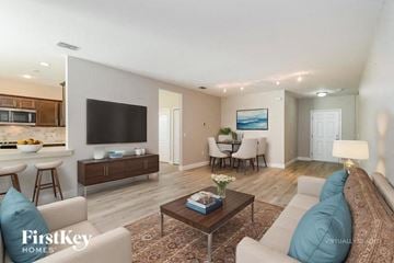 Cape Coral house for rent - A modern living room with a large couch and a television.