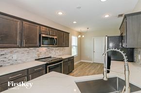Cape Coral house for rent - A kitchen with a stove top oven and a microwave built into the cabinetry.