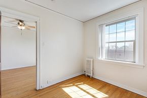 Denver apartment for rent - A living room with a grey couch, a white coffee table, and a ceiling fan.