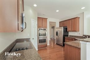 Concord house for rent - a kitchen with granite counter tops and wooden cabinets and stainless steel appliances