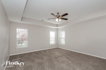 Concord house for rent - a living room with carpet and a ceiling fan