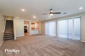 Mesa house for rent - A spacious living room with a staircase leading to the upper floor.