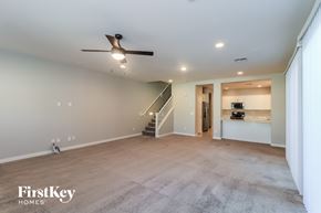 Mesa house for rent - A spacious room with a fan and stairs leading to another level.