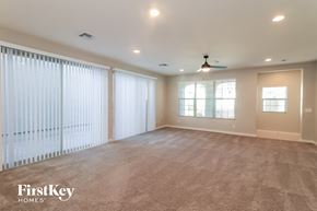 Mesa house for rent - A spacious room with a carpeted floor and a ceiling fan.
