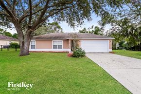 Deltona house for rent - a small pink house with a yard and a tree