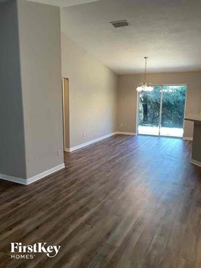 Deltona house for rent - an empty living room with wood floors and a sliding glass door