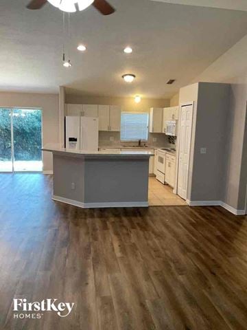 Deltona house for rent - an open kitchen with a large island and white cabinets