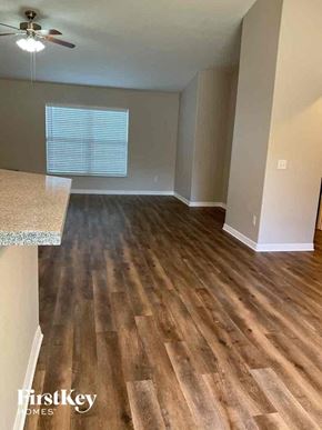Deltona house for rent - an empty kitchen and living room with wood flooring