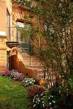 Brookline apartment for rent - a staircase in front of a brick house with plants and flowers